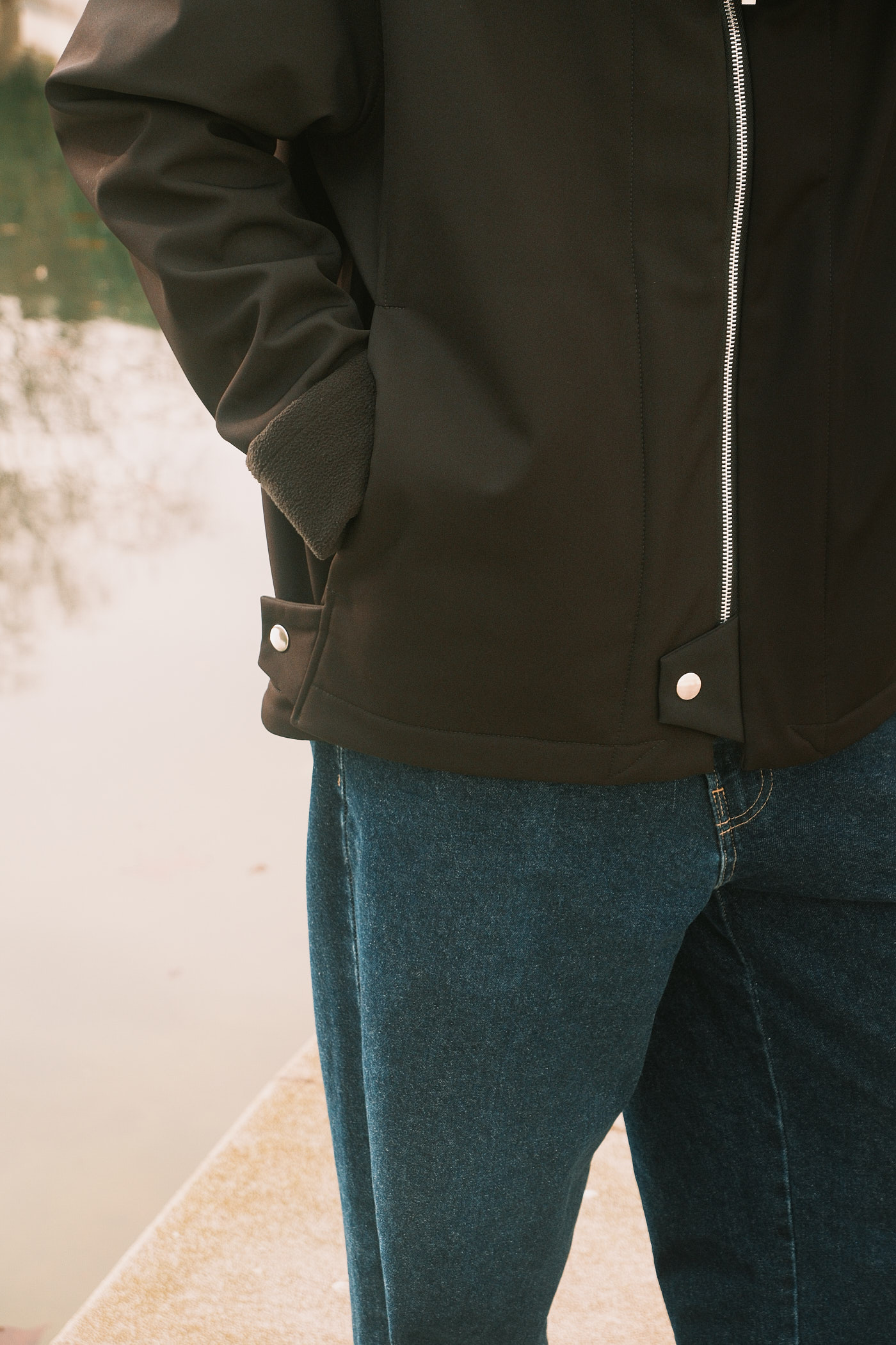 Detalle de cremallera YKK plateada sobre tejido softshell negro